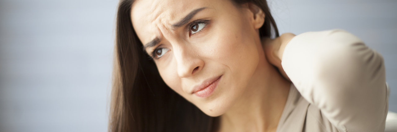 How My Panic Disorder Diagnosis Brought Me Relief woman with worried expression holding back or neck