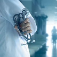 doctor standing in a hospital corridor holding a stethoscope