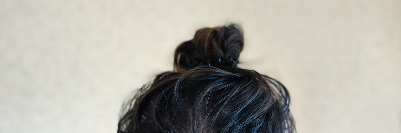 Why Depression Makes You Feel 'Gross' Woman with her hair in a bun