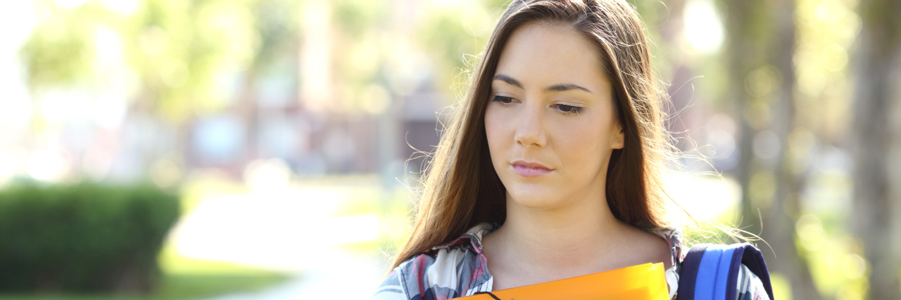 Why Finishing High School Online Was Better for My Health A high school student carrying her book and backpack, looking upset.
