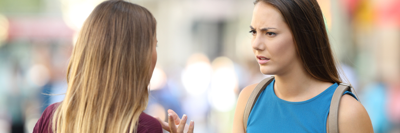 Your Two-Week Long Concussion Vs. My Brain Injury Two women talking seriously on the street.
