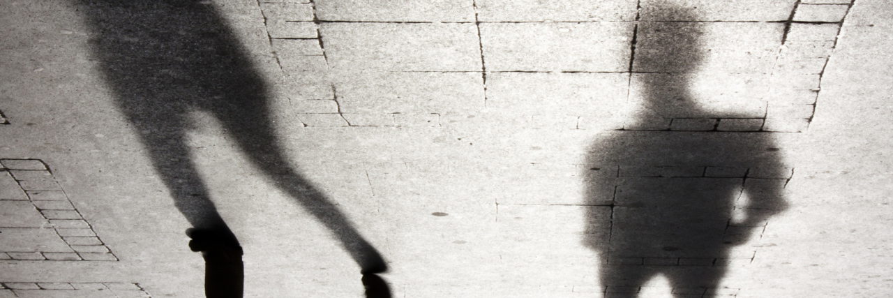 How It Feels to Be Catcalled as a Survivor of Sexual Abuse Upside down shadow of two person on city sidewalk in black and white