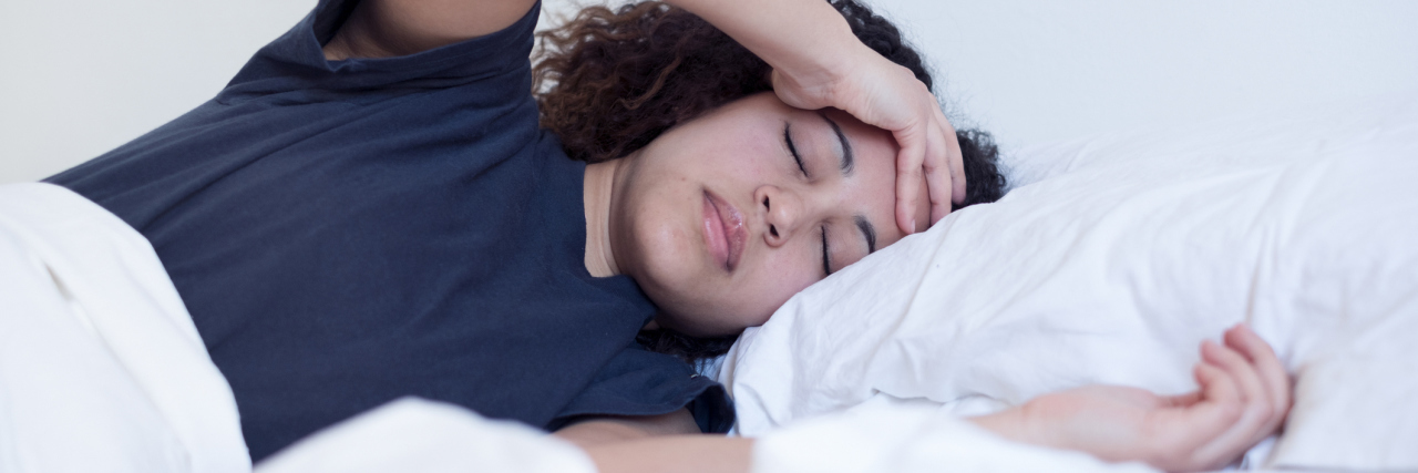 woman lying in bed with headache or depression