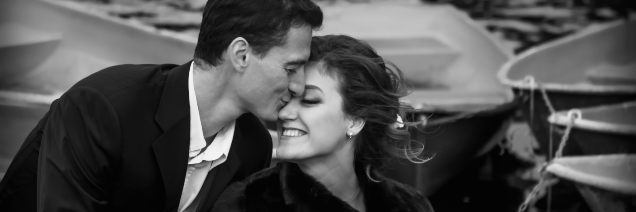 black and white photo of a couple kissing on a boat