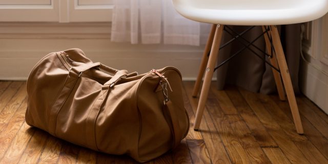 What I Keep in My 'Endometriosis Hospital Bag' A duffle back by a white chair.