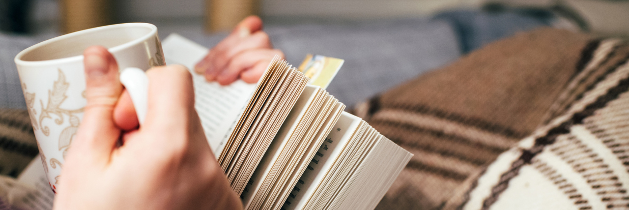 The Skills You Learn Through Living With Chronic Illness woman holding a book and a mug of tea