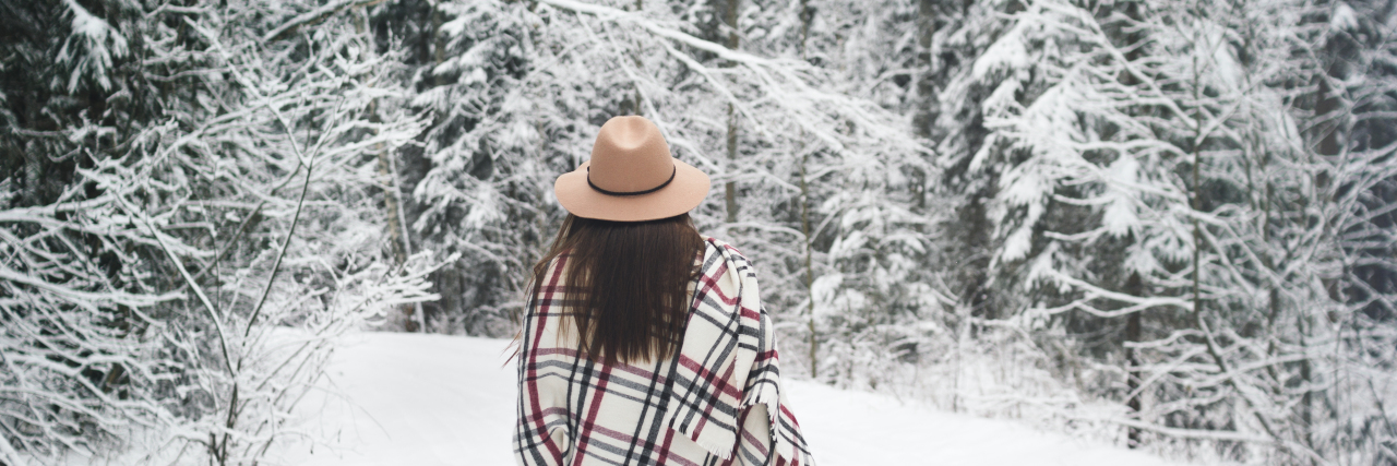 Living With the Ups and Downs of Ankylosing Spondylitis Young woman traveler in hat and scarf hold map in hand. Boho style