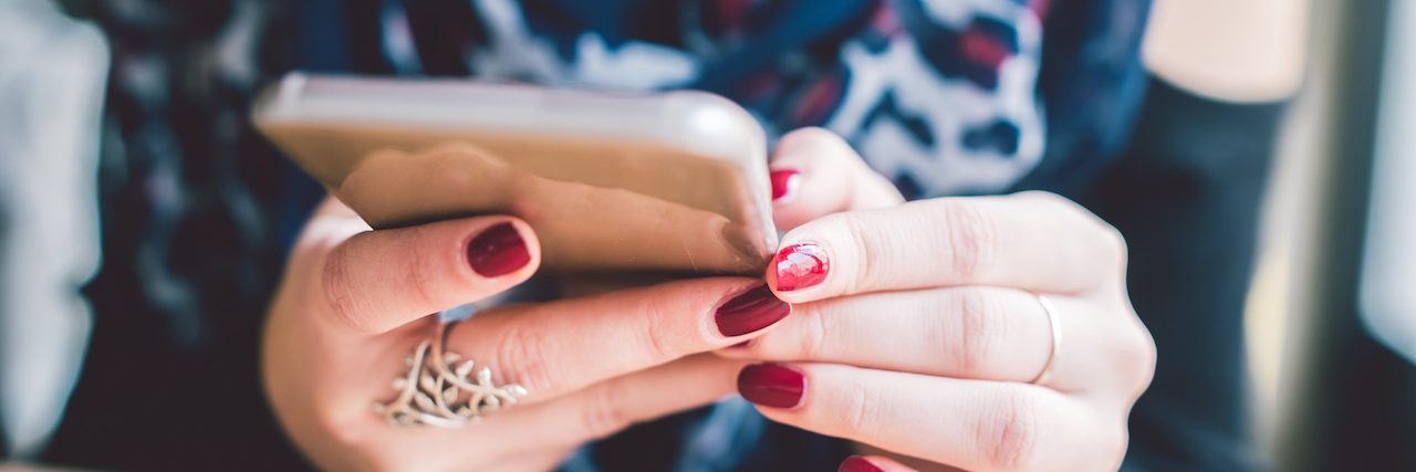 Facebook Says Its Updates Is Good for Mental Health A closeup shot of a girl's hands with red nails holding a smartphone