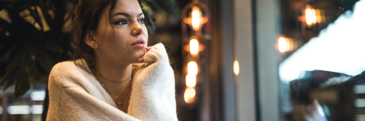 dark haired woman looking out window