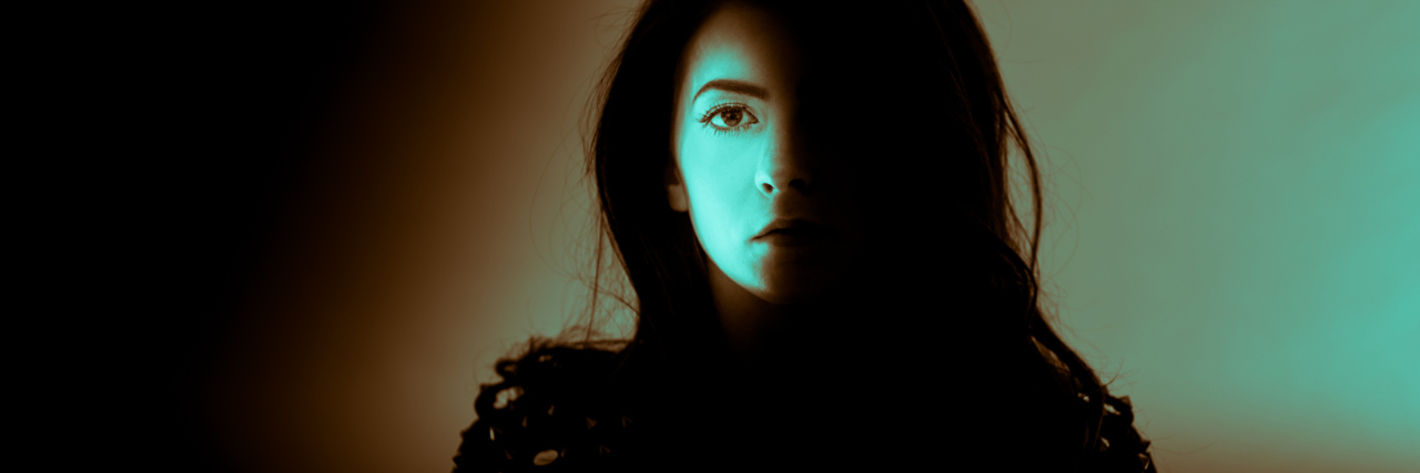 The Fear of Making Commitments With Fibromyalgia woman partially covered by brown and green shadows