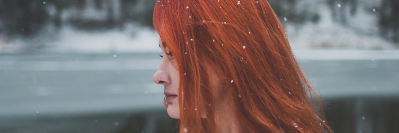 When Friends Can't See Past the Limitations of Your Illness A woman outside in the snow, look away from the camera.
