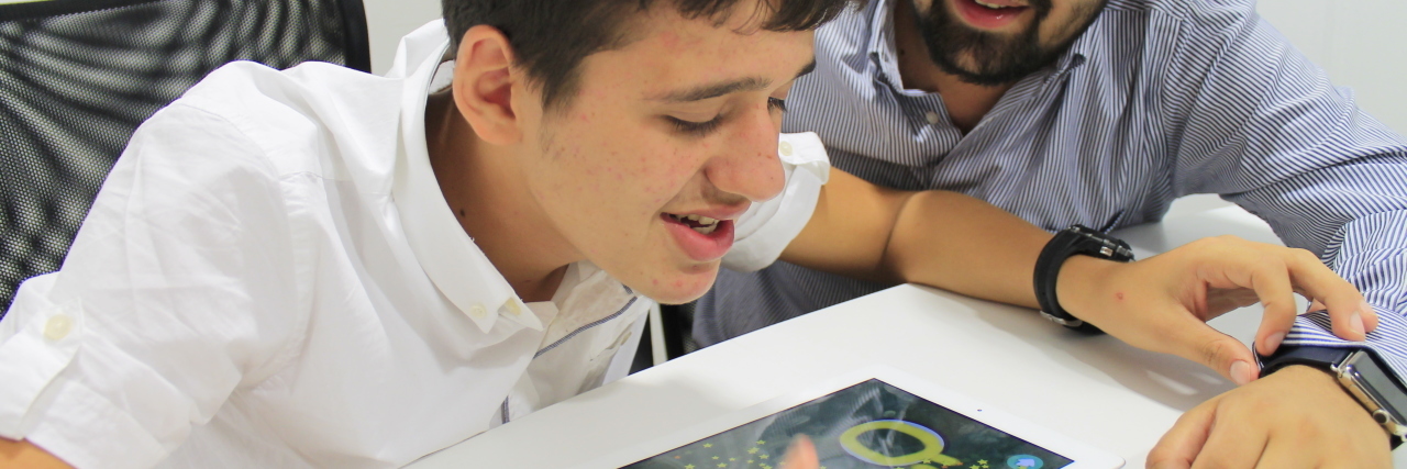 Education App for Children With Autism Zafer looks on as his brother uses the Otsimo app.