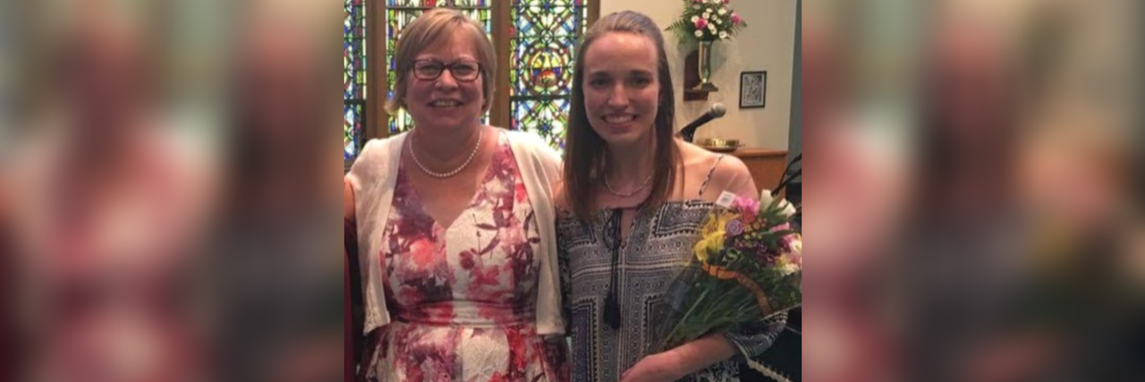Thank You to My Mentor for Loving Me Through Crohn's Disease two women wearing dresses and stained in a church holding flowers