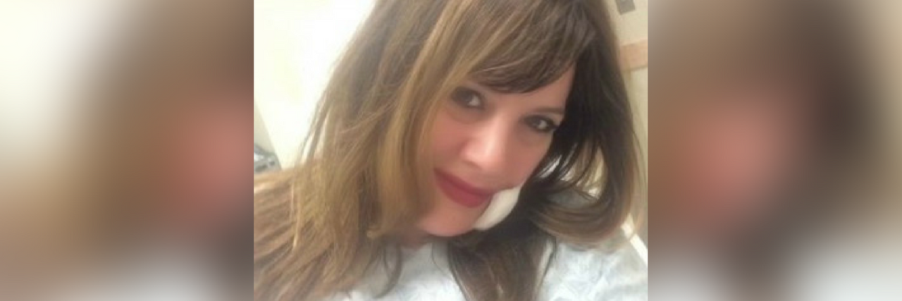 What It Was Like to Have Basal Cell Carinoma woman wearing a hospital gown with gauze and a bandage on her cheek after surgery