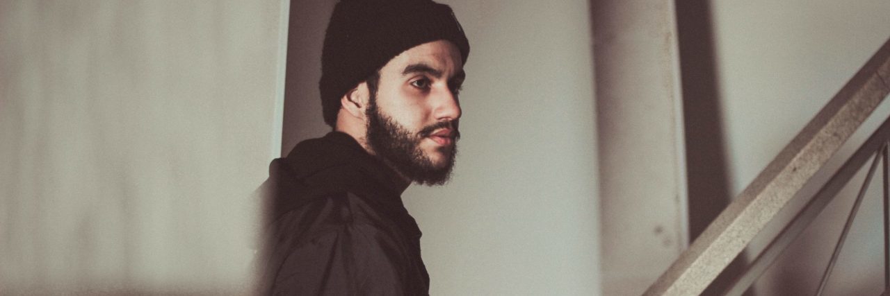 What I Realized About Depression When Coming Off Medication side view of man with beard in hallway on stairs