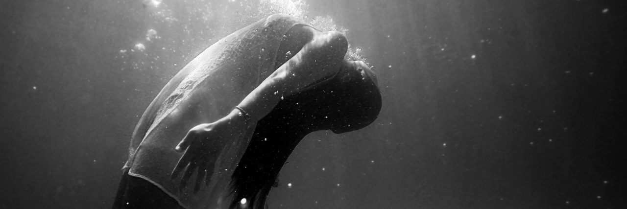 Woman underwater black and white arched back