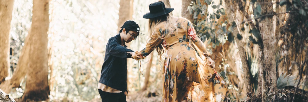 To My Significant Other Who Has to Fight My Mental Illness Too couple walking helping each other over tree stump