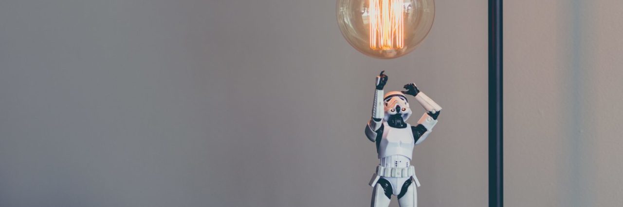 storm trooper star wars toy looking up at edison lightbulb