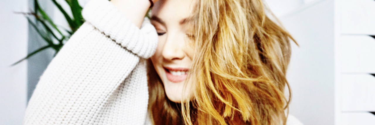 Can You Have Social Anxiety and Still Talk a Lot young woman smiling and running hand back through hair