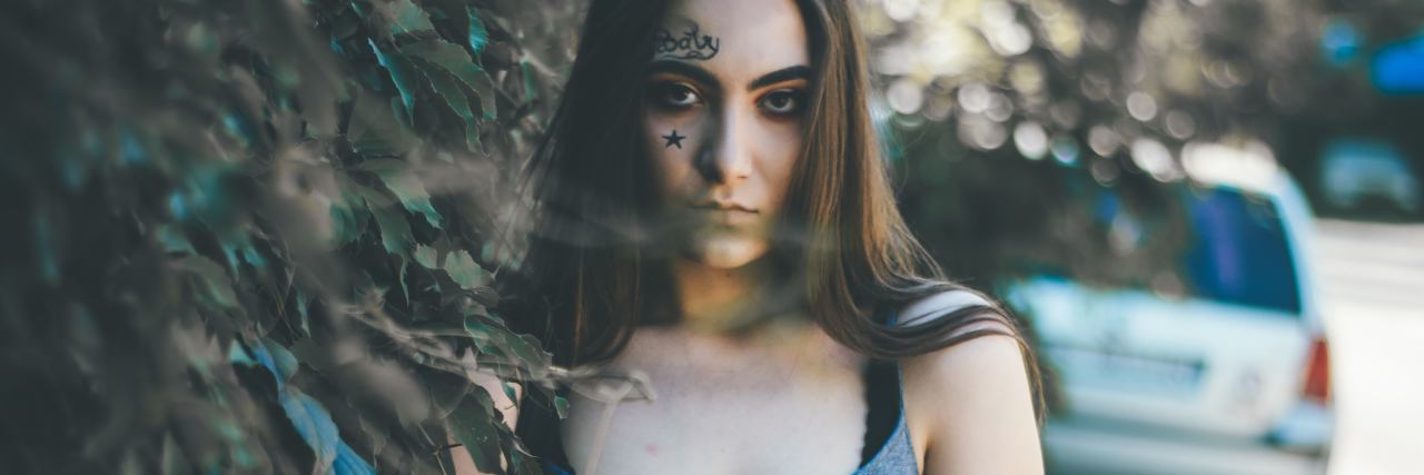 Why I'm Angry About My Childhood Trauma woman standing by tree looking angry