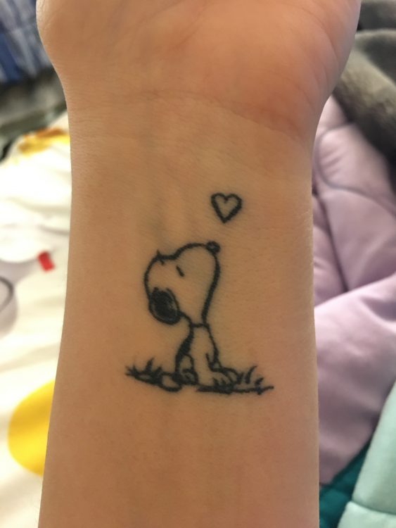 tattoo of Snoopy on woman's wrist