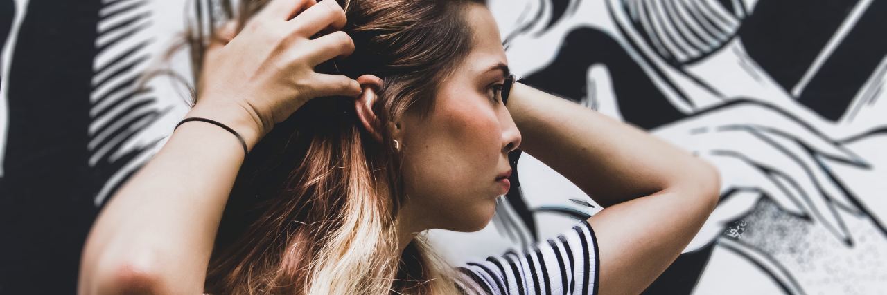 How Getting a Tattoo Helped Me Manage My Self-Harm Urges woman running fingers through hands