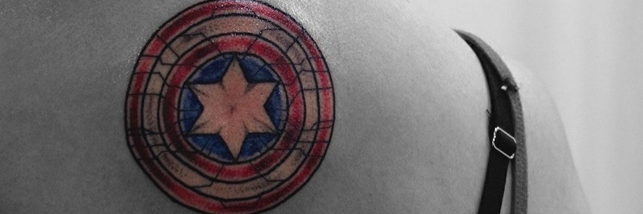 What My Tattoos Say About My Chronic Pain A black and white image of the back of the writer, with her tattoo in color.