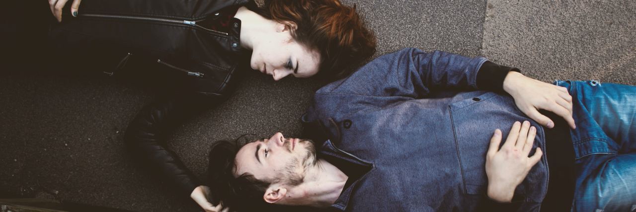 How to Support Your Partner Through Eating Disorder Recovery couple laying on pavement looking at one another