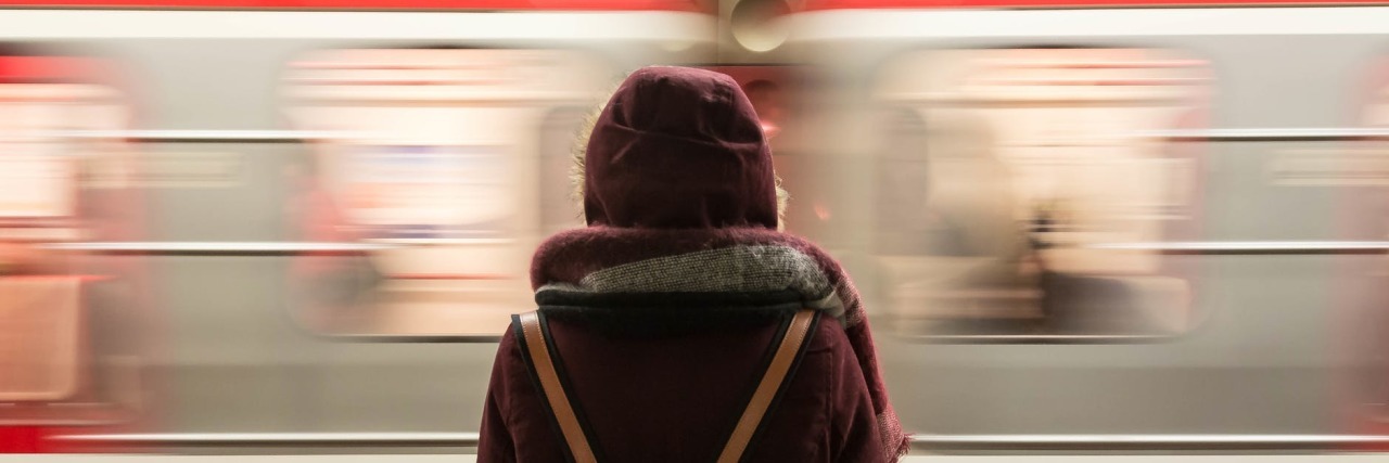 When Mental Illness Makes You Feel Like an 'Imposter' in Your Own Life woman in front of train