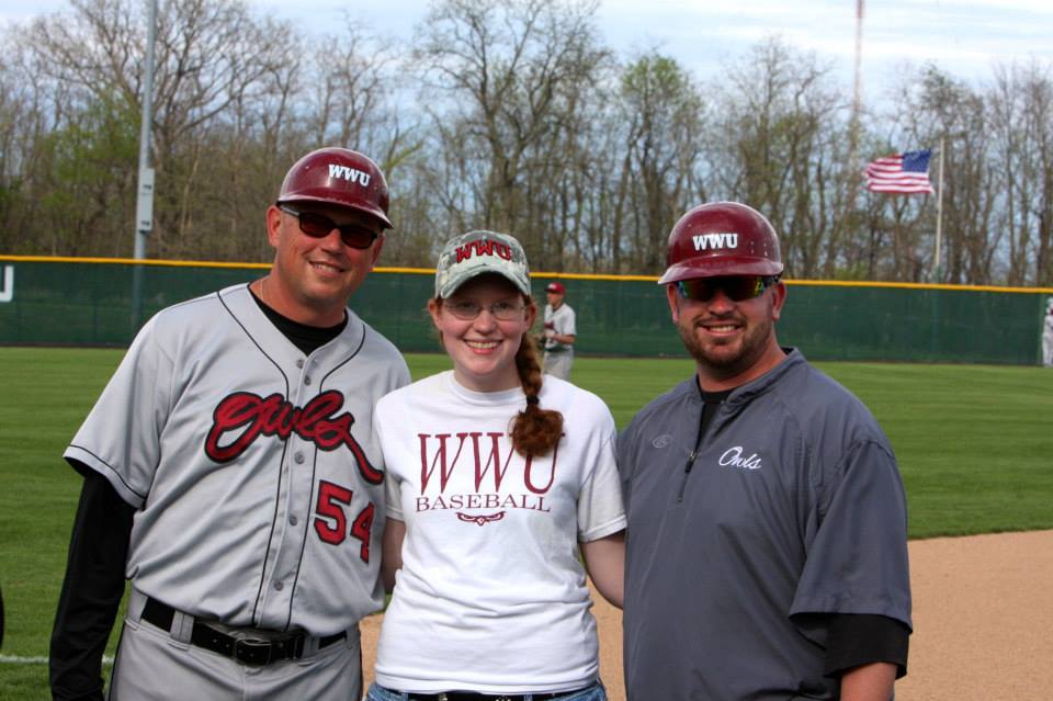 A photo of the writer with the coaches on senior day.