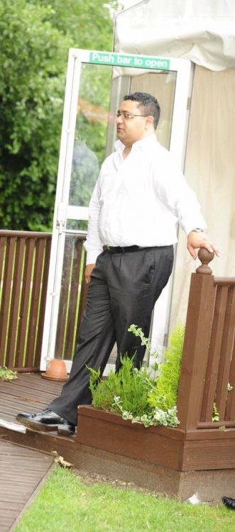 man wearing dress clothes and standing outside in his yard