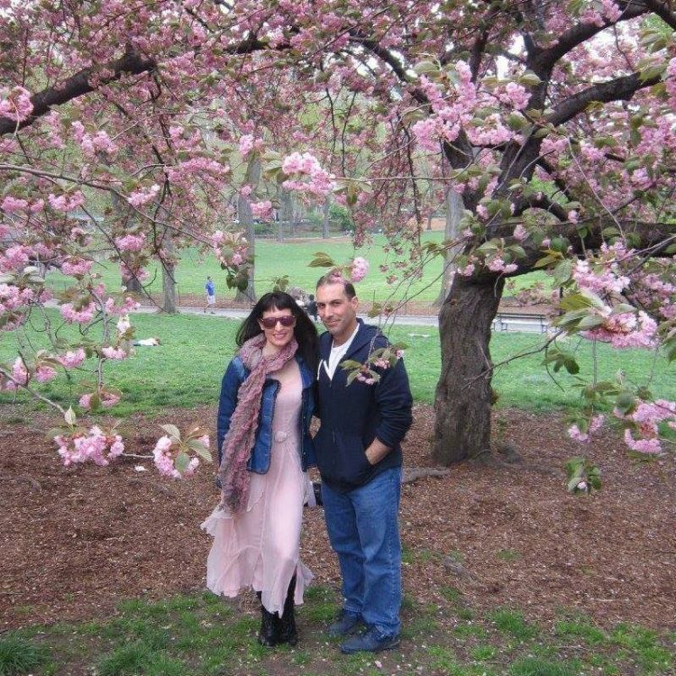 Author and husband standing under a cherry blossom tree