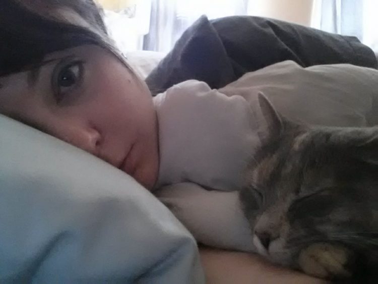 woman lying in bed with cat