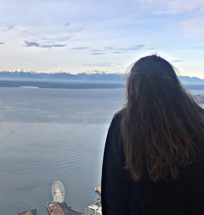 woman looking at ocean by Seattle