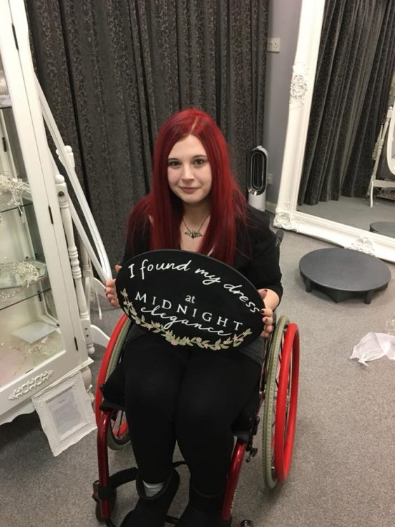 woman in wheelchair holding sign that says i found my wedding dress