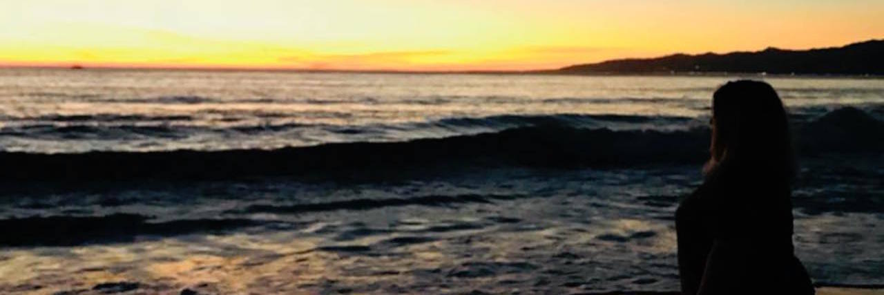 We Need Better Understanding of Endometriosis woman standing on the beach at sunset with the hashtag "I'll rise up"