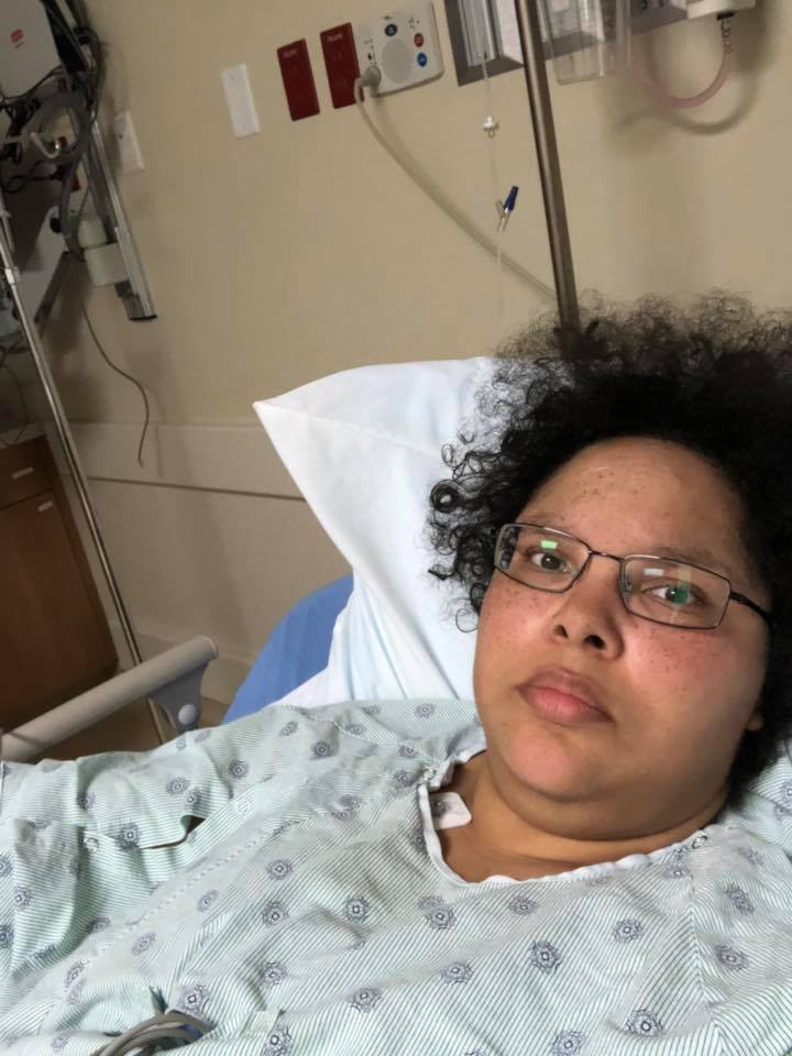 woman lying in a hospital bed and wearing a hospital gown