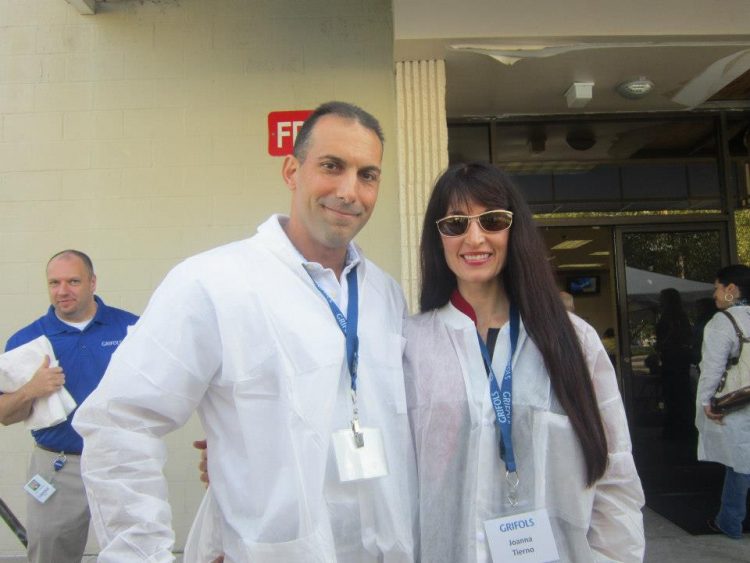 The author and her husband standing with white coats on while visiting Grifols