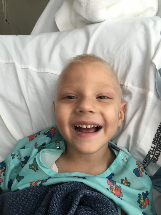 Dax smiling in the hospital without hair