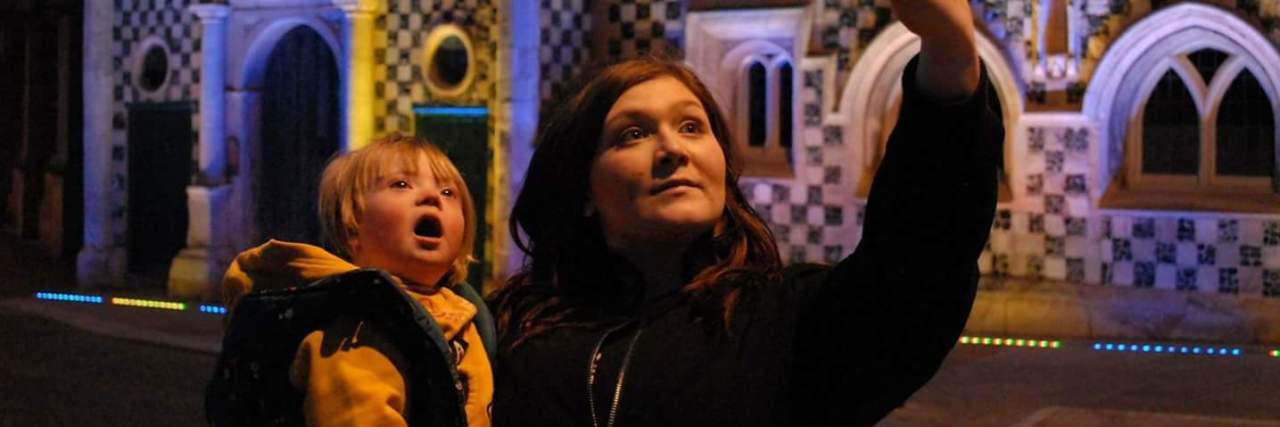 A Sibling's Guide to Down Syndrome Sister holding brother with Down syndrome and taking a selfie