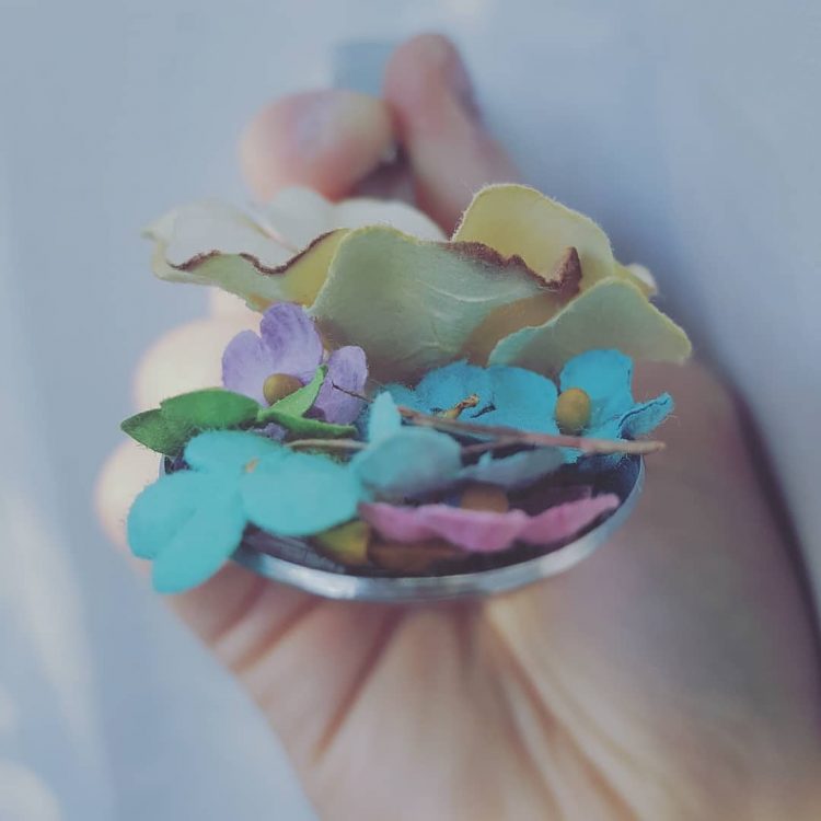 a woman feeding herself flowers on a spoon