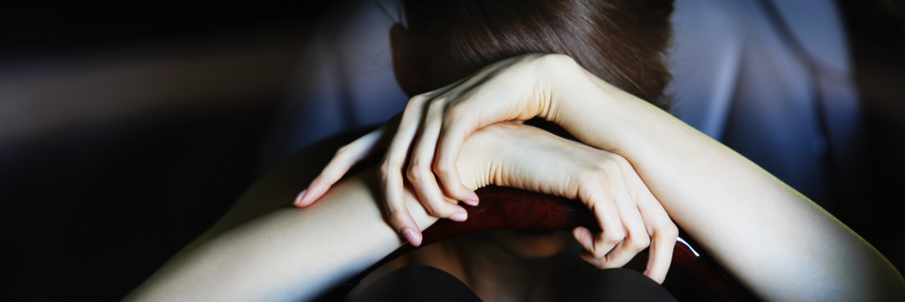 The Diagnosis That Pulled Me Into a Deep Depression A woman leaning on her steering wheel.