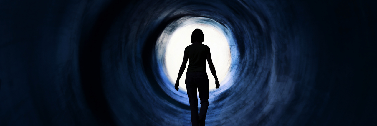 What Bipolar Mania Thoughts Are Like Woman is walking towards glaring light. it May symbolise escape, looking for exit or freedom and even death or clinical death. Psychedelic vision. Photo manipulation.