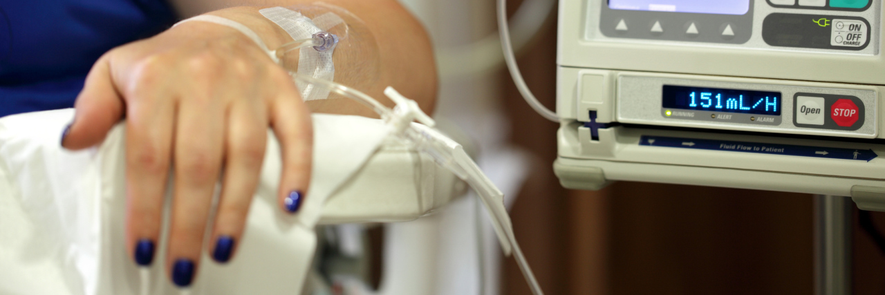 A photo of a woman arm attached to an IV.