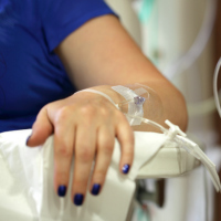 A photo of a woman arm attached to an IV.