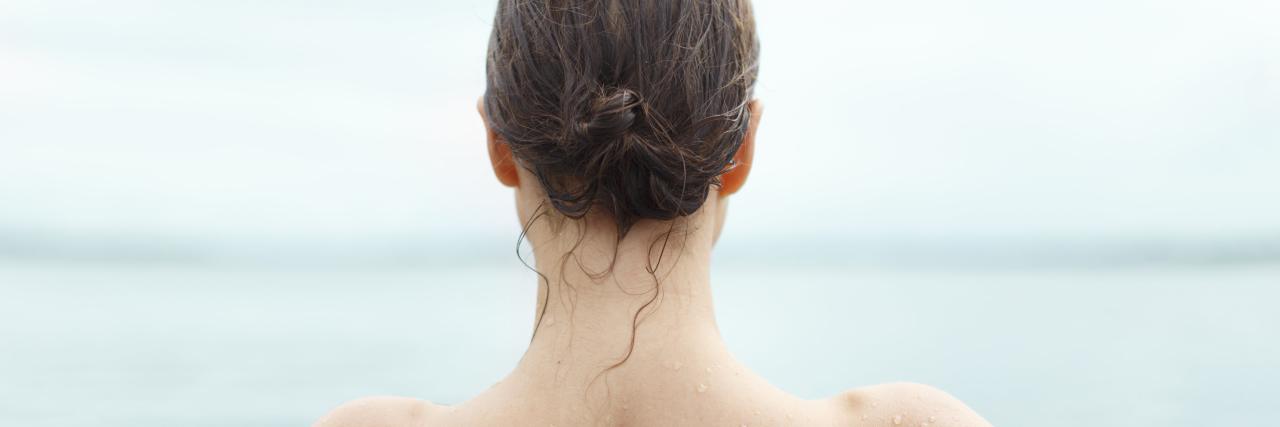 photo of back of woman swimming in the ocean with wet hair