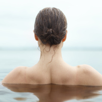photo of back of woman swimming in the ocean with wet hair