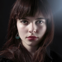 portrait of a woman with dark hair and bangs looking at the camera