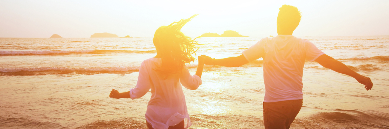 If You're Dating While Chronically Ill A couple walking on the beach.