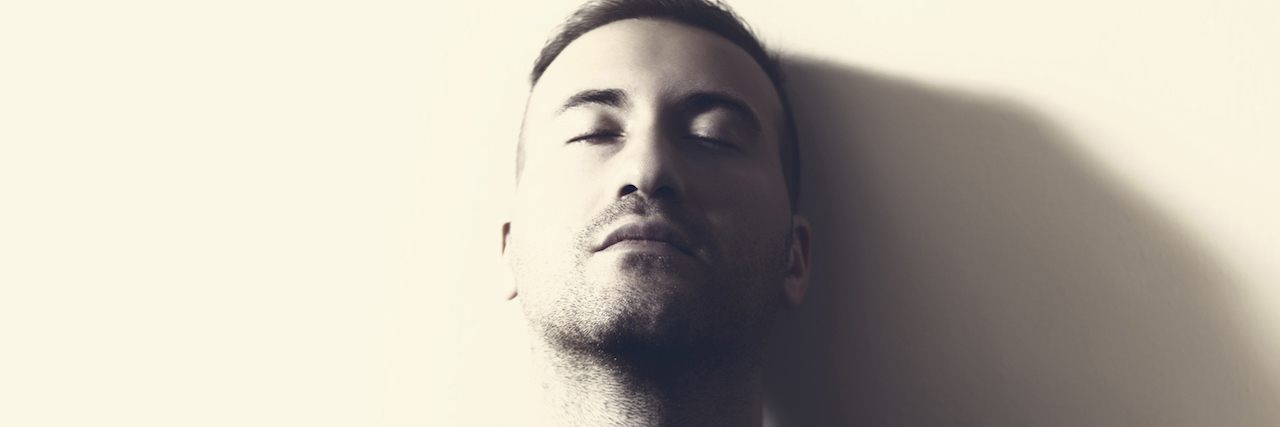 What It's Like to Be a Man With Depression Portrait of a a man who lean against the wall with his back.